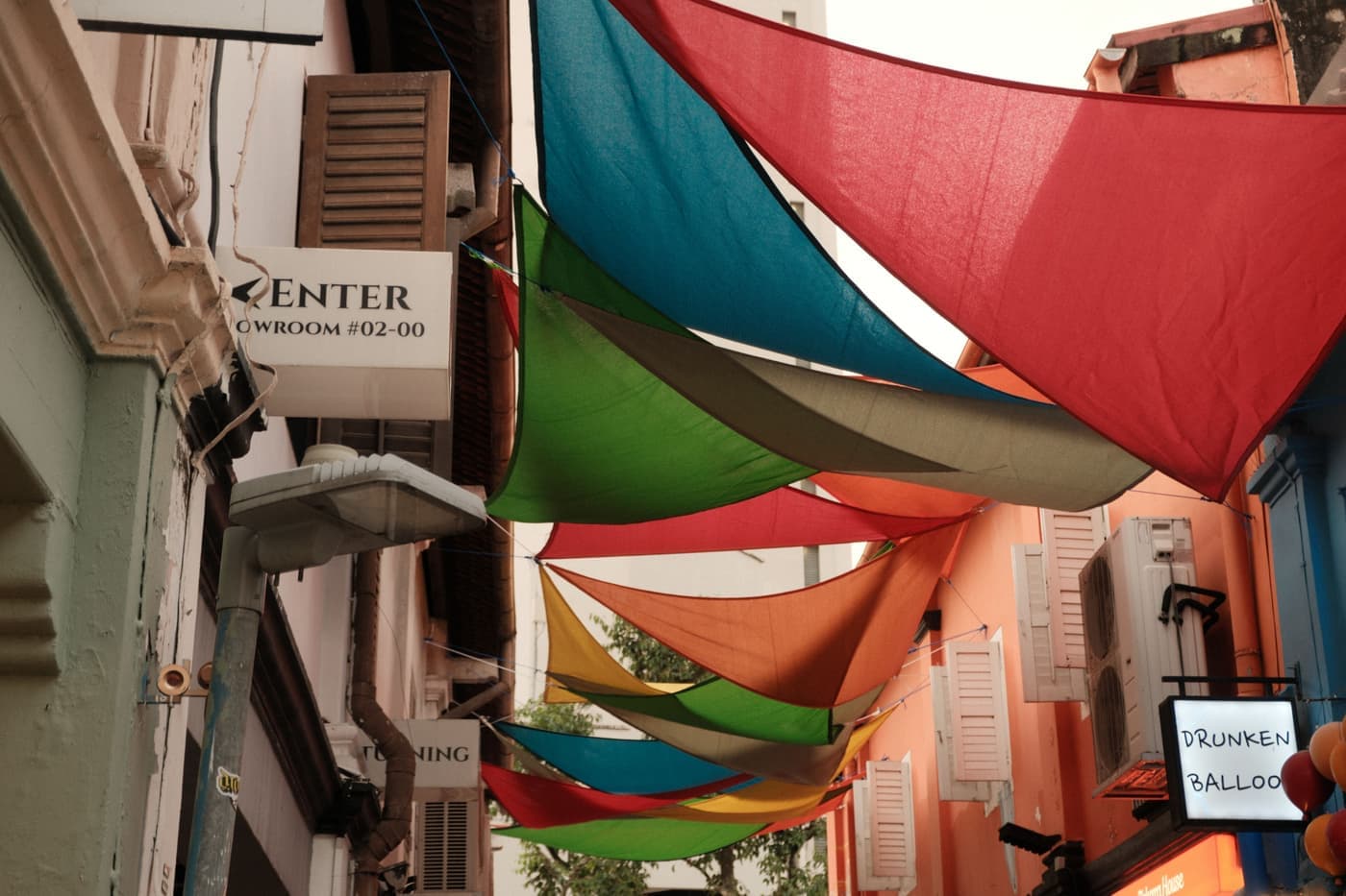 Triangular shade sail tensioned between posts above a backyard patio, seen from below