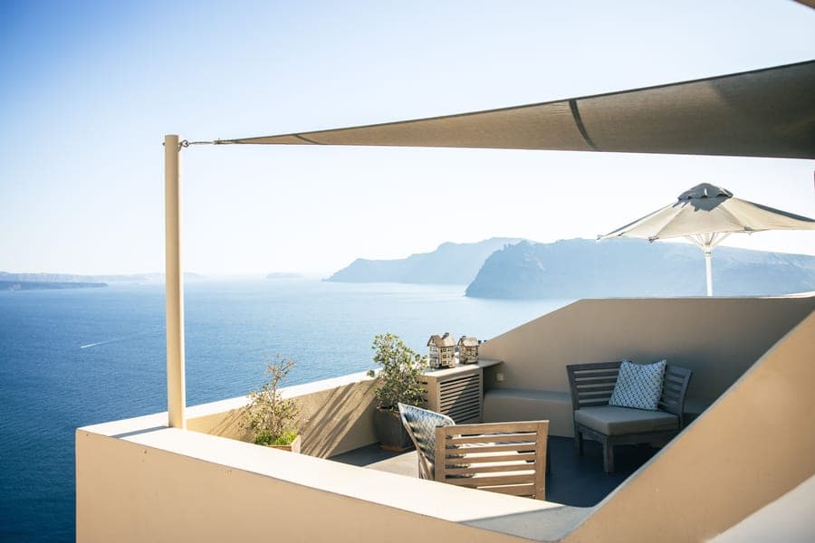 Rectangular HDPE shade sail tensioned between posts above a backyard seating area